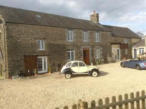 un coche viejo aparcado frente a una casa de ladrillo en Le Bois Gautier en Savigny-le-Vieux