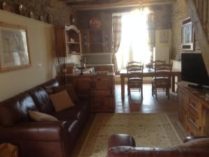 a living room with a couch and a dining room at Le Bois Gautier in Savigny-le-Vieux