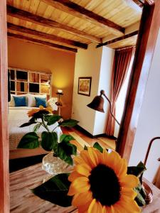 1 dormitorio con 1 cama y una flor en el suelo en Old Town Quito Suites, Heritage Boutique Hotel, Where Every Detail Tells a Story, en Quito