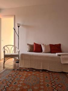a living room with a bed and a chair at Casa Vacanze Giulienso in Ardea