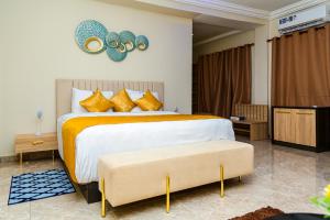 a bedroom with a large bed with gold pillows at Marlin All Inclusive Resort in Kasoa
