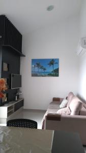 Habitación blanca con cama, mesa y TV. en Duplex-318 até 8 pessoas, en Florianópolis
