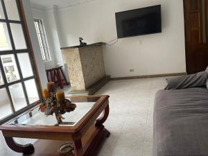 sala de estar con mesa de cristal y TV en Quiet apartment in Laureles, en Medellín