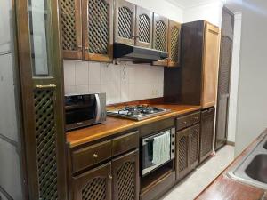 cocina con armarios de madera y horno con fogones en Quiet apartment in Laureles, en Medellín
