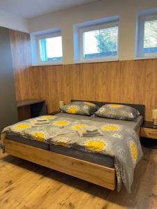 a bedroom with a bed in a room with windows at Apartmán TATRAFUN in Vysoke Tatry - Tatranska Lomnica.