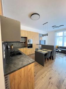 a kitchen and living room with a table and chairs at Apartmán TATRAFUN in Tatranská Lomnica