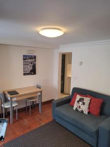 Cozy Estrela Apartment في لشبونة: غرفة معيشة مع أريكة وطاولة
