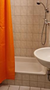 ドレスデンにあるInnenstadt-Appartementのバスルーム(シンクの横にオレンジ色のシャワーカーテン付)