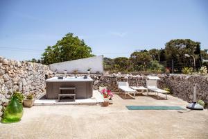 a patio with a stone wall and a hot tub at Masseria Murgia Albanese in Noci