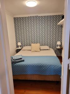 a bedroom with a bed with a blue patterned wall at Cozy Estrela Apartment in Lisbon