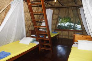 a room with two bunk beds and a ladder at Posada del Cerro in El Remate