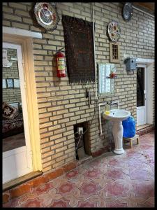 baño con lavabo y pared de ladrillo en Masturabonu Ravshan, en Bukhara