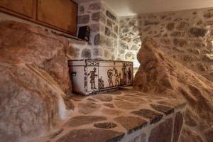 een keuken met stenen muren en een stenen vloer bij Braxos A beautiful rocky place in Hydra