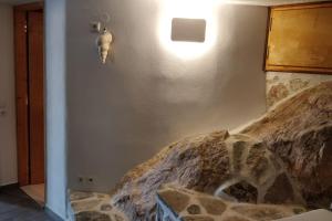 a room with a large rock on the wall at Braxos A beautiful rocky place in Hydra