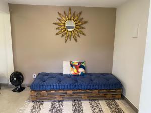 ein blaues Sofa in einem Zimmer mit Spiegel in der Unterkunft Cantinho na natureza perto das praias in Niterói