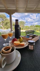 uma mesa com um prato de comida e copos de vinho em La Pasionaria casa de sierras em Santa Rosa de Calamuchita