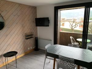 uma sala de jantar com uma mesa e uma janela em Appartement agréable à deux pas du plan d'eau em Embrun
