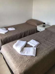 2 camas en una habitación con toallas en la cama en La Pasionaria casa de sierras, en Santa Rosa de Calamuchita 9 fotos más