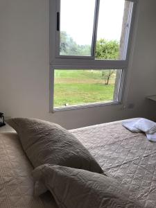 a bedroom with a bed and a window at La Pasionaria casa de sierras in Santa Rosa de Calamuchita
