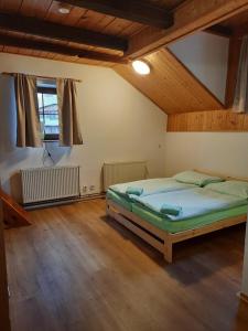 Chata Resort Na Horské في مالا مورافكا: غرفة نوم بسرير في غرفة ذات أرضيات خشبية