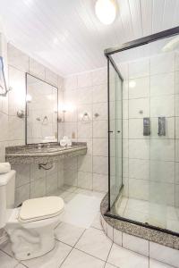 a bathroom with a toilet and a glass shower at Samba Laguna Tourist Hotel in Laguna