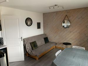 uma sala de estar com um sofá e uma mesa em Appartement agréable à deux pas du plan d'eau em Embrun