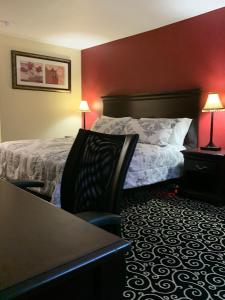 a hotel room with a bed and a table and chairs at FairBridge Inn Express Hiawatha in Hiawatha