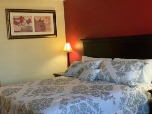 a bedroom with a bed with blue and white pillows at FairBridge Inn Express Hiawatha in Hiawatha