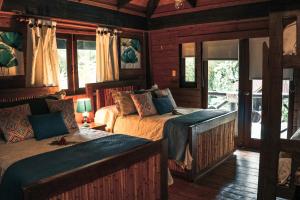 a bedroom with two beds and a couch at Platon Ecolodge in Santa Cruz de Barahona