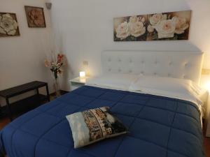 a bedroom with a blue bed and a painting of roses at La Piccola Oasi con parcheggio in Florence