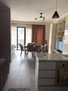a kitchen and living room with a table and chairs at Vitali Apartment in Borjomi