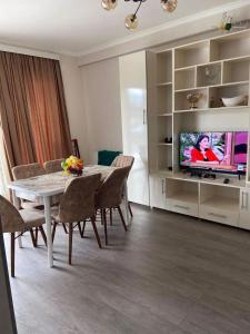 a living room with a dining table and a television at Vitali Apartment in Borjomi