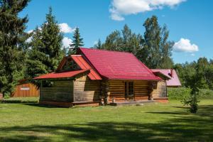 une cabane en rondins avec un toit rouge dans l'établissement Väike Kuu peamaja, à Myza Kastre