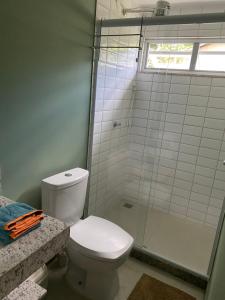 uma casa de banho com um WC e uma cabina de duche em vidro. em Cantinho na natureza perto das praias em Niterói
