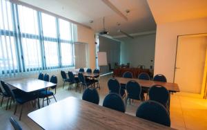 sala konferencyjna ze stołami, krzesłami i oknami w obiekcie Hotel Lux w mieście Modena