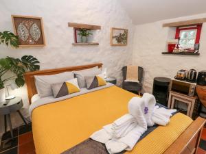 a bedroom with a yellow bed with towels on it at The Old Dairy in Pembroke