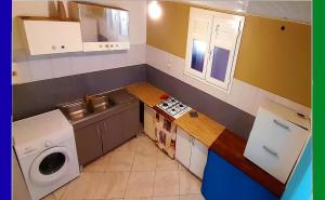 a small kitchen with a washing machine and a washer at Hostel des 3 sources in Sainte-Marie