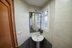 W łazience znajduje się umywalka i lustro. w obiekcie Hostal Molgas w mieście A Medorra