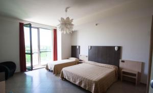 sypialnia z 2 łóżkami i dużym oknem w obiekcie Hotel Lux w mieście Modena +37 zdjęć