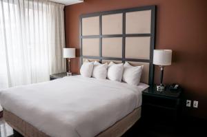 a large bed in a hotel room with two lamps at M Montreal Hostel in Montréal