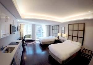 sypialnia z 2 łóżkami i kuchnia ze zlewem w obiekcie M Montreal Hostel w Montrealu
