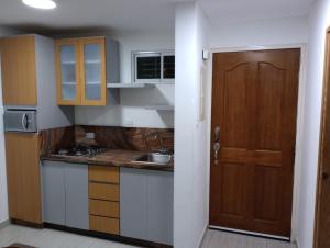 a kitchen with a sink and a wooden door at Villa La Blanquilla in Pampatar