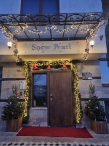 a front door of a snow pearl hotel with christmas lights at Snow Pearl Residence & FREE SPA in Bansko