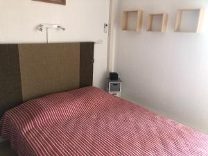ein Schlafzimmer mit einem Bett mit einer roten gestreiften Decke in der Unterkunft Location Vacances entre mer et montagnes in Argelès-sur-Mer