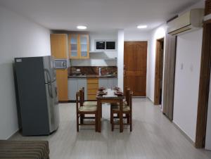 a kitchen with a table and chairs and a refrigerator at Villa La Blanquilla in Pampatar