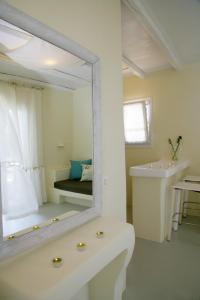 W łazience znajduje się lustro, umywalka i wanna. w obiekcie NINEMIA CALM AND SPA w mieście Kionia