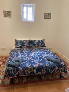 a bedroom with a bed with a blue blanket at Carolyn's Cottage in Adelaide