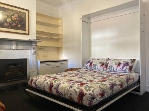 a bedroom with a bed and a fireplace at Carolyn's Cottage in Adelaide