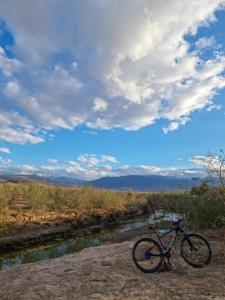 a bike parked on the side of a river at Les terrasses du Lac Marrakech in Lalla Takerkoust