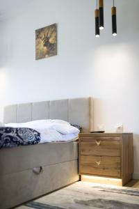 a bedroom with a bed and a wooden dresser at Apartament Stella in Karpacz